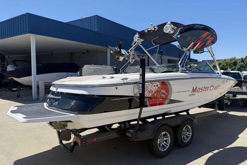 Slide: The Image of 2008 MasterCraft X-45 boat on trailer, parked outside a blue-roofed building. - 4