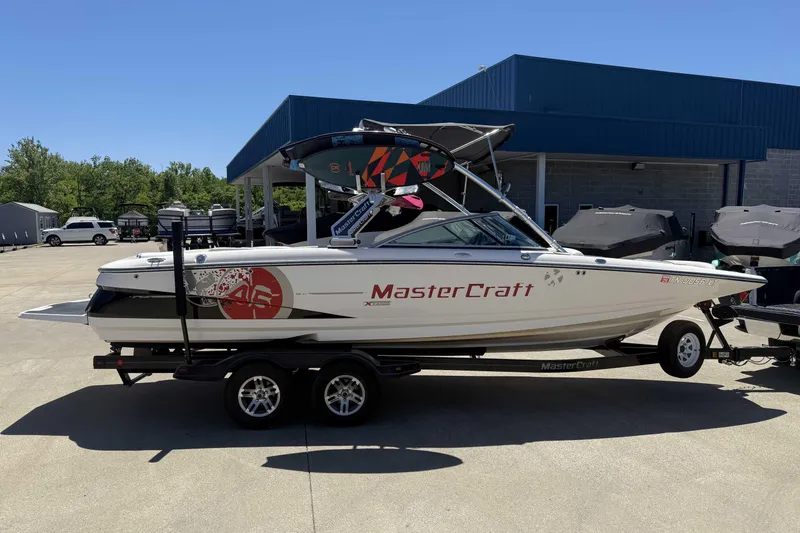 Slide: The Image of 2008 MasterCraft X-45 boat on trailer, parked outdoors under clear blue sky. - 5