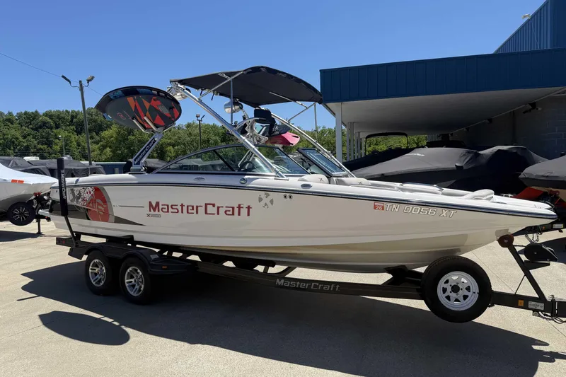 Slide: The Image of 2008 MasterCraft X-45 boat on trailer, parked outdoors under clear sky. - 6