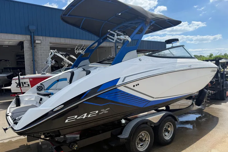 Slide: The Image of 2018 Yamaha Boats 242X E-Series covered on trailer, parked outdoors. - 1