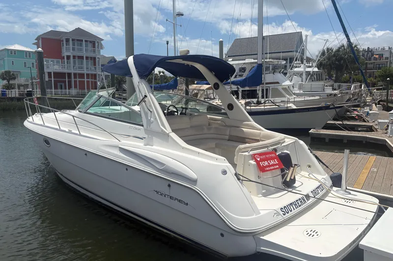 The Image of 2000 Monterey 322 Cruiser boat docked, for sale, with blue canopy and white exterior. - 1