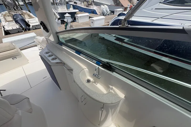 Slide: The Image of 2000 Monterey 322 Cruiser boat interior with sink and seating area at marina. - 10