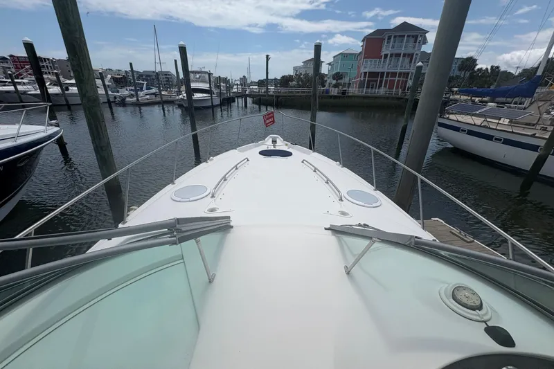 Slide: The Image of 2000 Monterey 322 Cruiser docked at a marina with surrounding boats and buildings. - 13