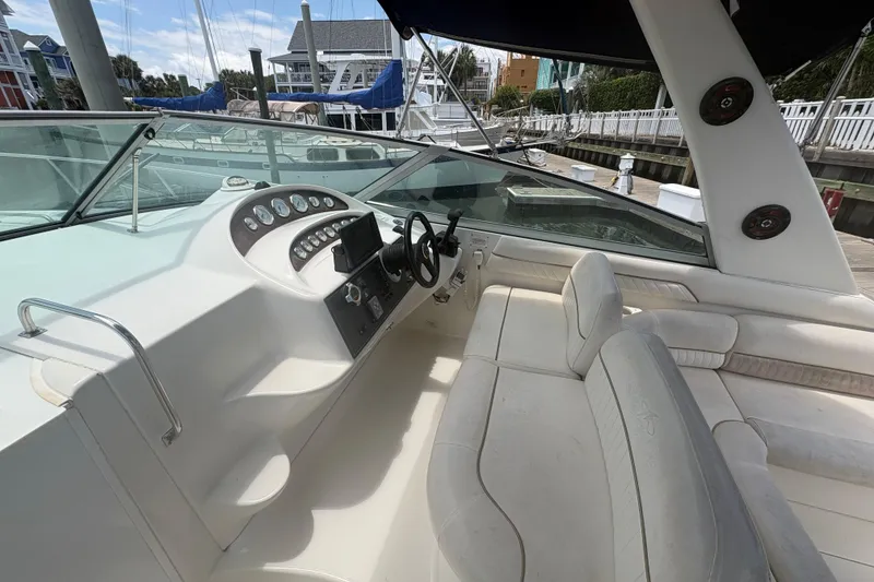 Slide: The Image of Cockpit of a 2000 Monterey 322 Cruiser with white seating and control panel. - 19