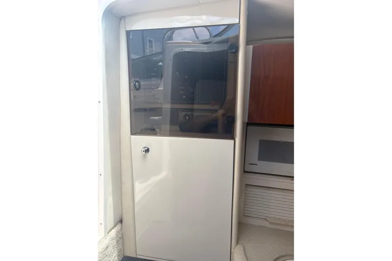 Slide: The Image of Interior view of a 2000 Monterey 322 Cruiser, featuring a cabin door and microwave. - 21