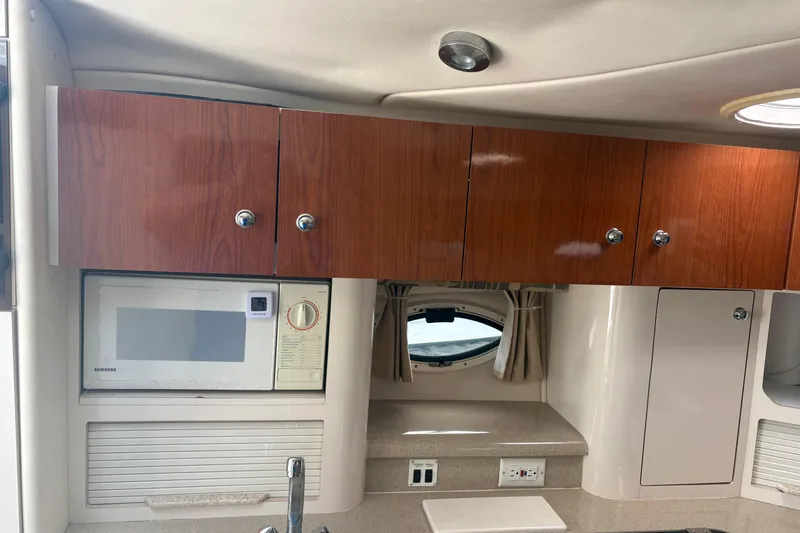Slide: The Image of Interior of 2000 Monterey 322 Cruiser with wooden cabinets and a built-in microwave. - 23