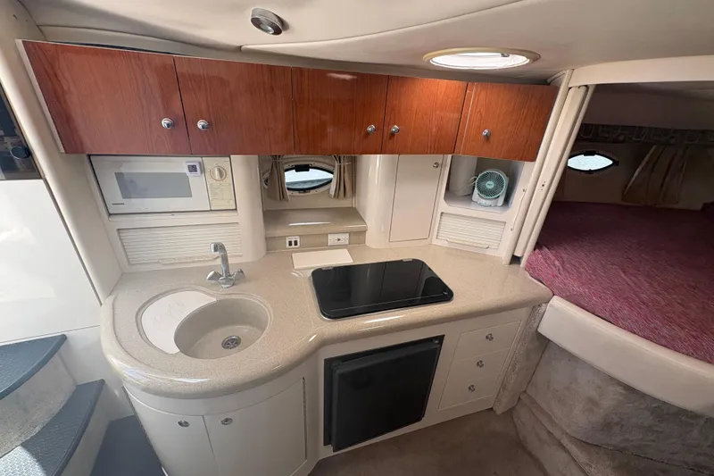 Slide: The Image of 2000 Monterey 322 Cruiser interior kitchen with sink, stove, and wooden cabinets. - 25