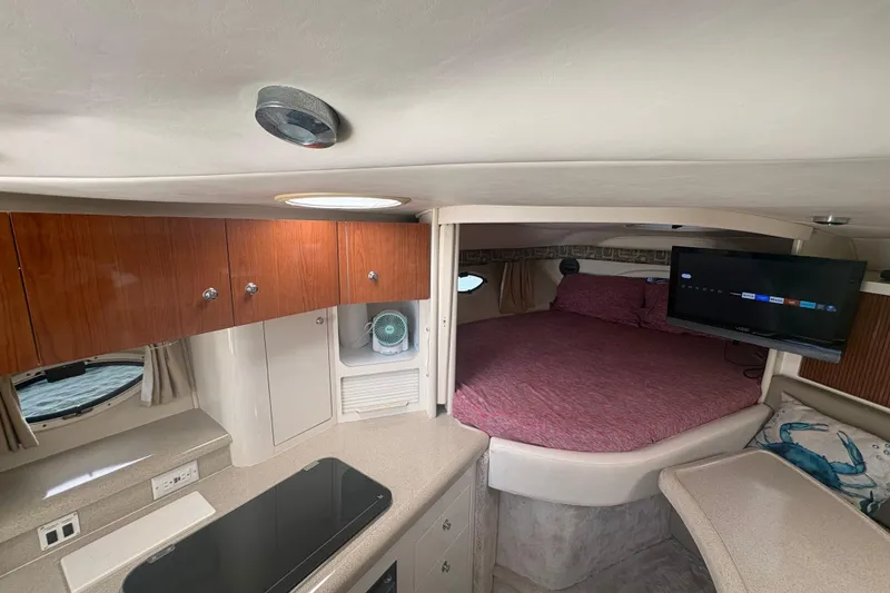 Slide: The Image of Interior of 2000 Monterey 322 Cruiser with bed, TV, and wooden cabinets. - 26
