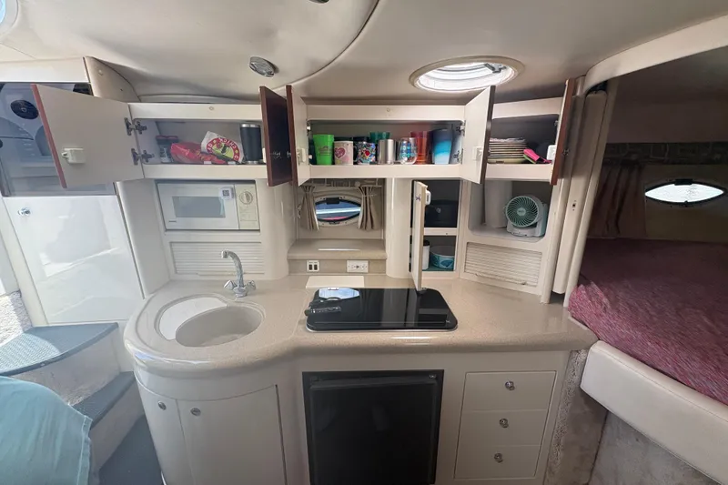 Slide: The Image of Interior of 2000 Monterey 322 Cruiser with kitchenette, open cabinets, and cozy sleeping area. - 32