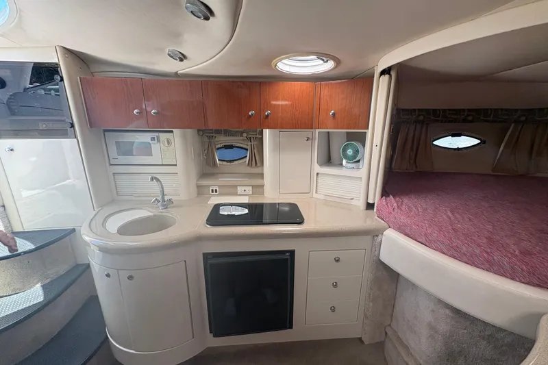 Slide: The Image of Interior of a 2000 Monterey 322 Cruiser featuring a compact kitchen and cozy sleeping area. - 33