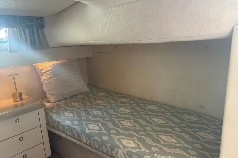 Slide: The Image of Cozy cabin interior of 2000 Monterey 322 Cruiser with patterned bedding and soft lighting. - 39