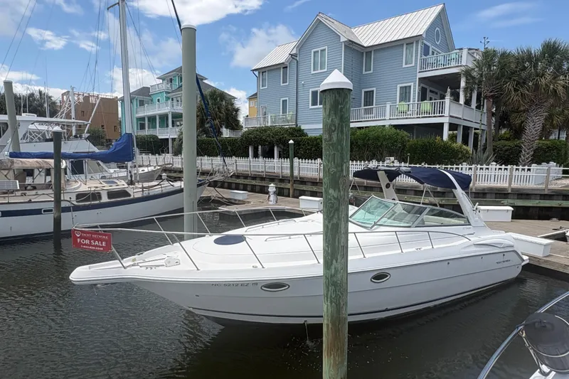 Slide: The Image of 2000 Monterey 322 Cruiser boat docked, for sale, with coastal homes in the background. - 4