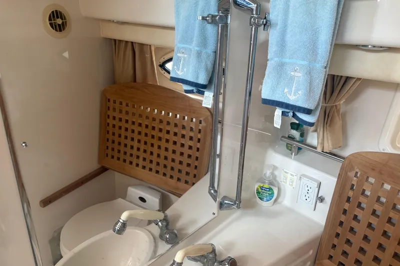 Slide: The Image of Bathroom interior of 2000 Monterey 322 Cruiser with sink, mirror, and nautical-themed towels. - 42