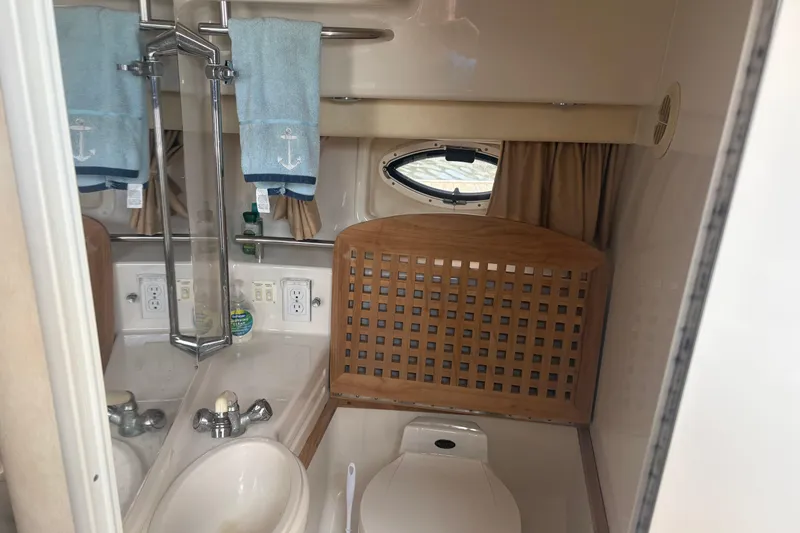 Slide: The Image of Bathroom interior of 2000 Monterey 322 Cruiser with sink, toilet, and nautical-themed towels. - 45