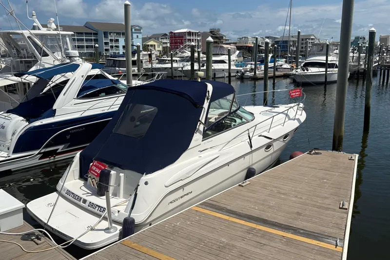Slide: The Image of 2000 Monterey 322 Cruiser docked at marina, for sale sign visible. - 54