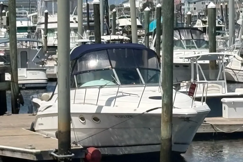 Slide: The Image of 2000 Monterey 322 Cruiser docked at a marina, surrounded by other boats. - 55