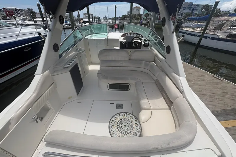 Slide: The Image of 2000 Monterey 322 Cruiser boat interior with seating, docked at marina. - 6