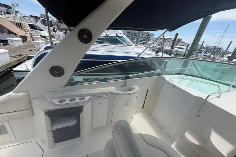 Slide: The Image of 2000 Monterey 322 Cruiser interior with seating and docked boats in background. - 9
