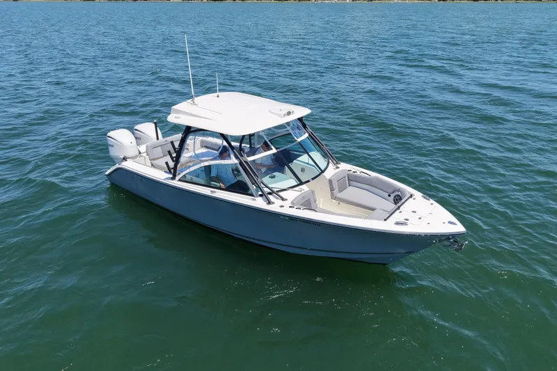 The Image of 2024 Cobia 280 Dual Console boat on open water, showcasing sleek design and twin engines. - 0