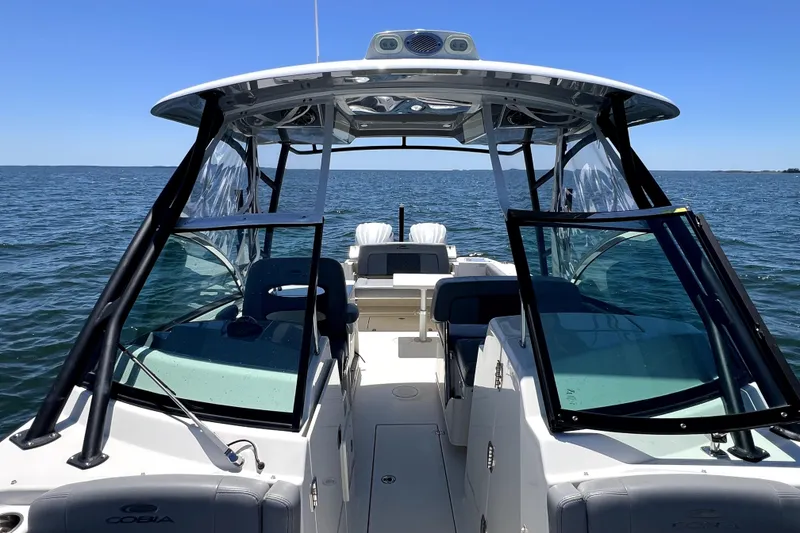 Slide: The Image of 2024 Cobia 280 Dual Console boat on open water, showcasing spacious seating and sleek design. - 12