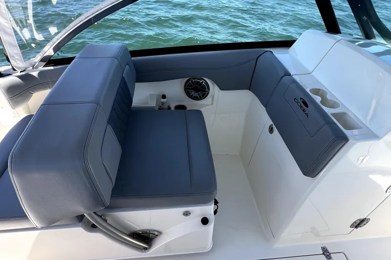 Slide: The Image of 2024 Cobia 280 Dual Console boat interior with gray seating and cup holders. - 13