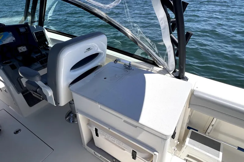 Slide: The Image of 2024 Cobia 280 Dual Console boat interior with helm and seating area. - 15