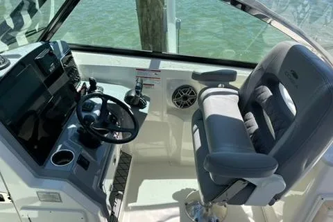 Slide: The Image of 2024 Cobia 280 Dual Console boat interior with steering wheel and comfortable seating. - 16