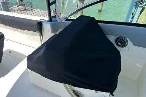 Slide: The Image of 2024 Cobia 280 Dual Console boat interior with covered equipment and speaker. - 27
