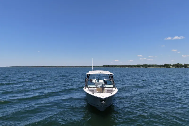 Slide: The Image of 2024 Cobia 280 Dual Console boat on open water under clear blue sky. - 7