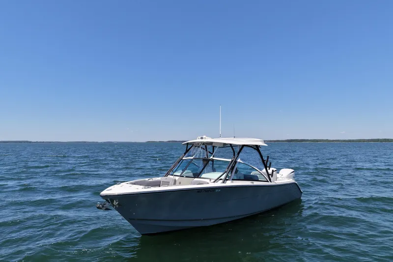 Slide: The Image of 2024 Cobia 280 Dual Console boat on open water under clear blue sky. - 8