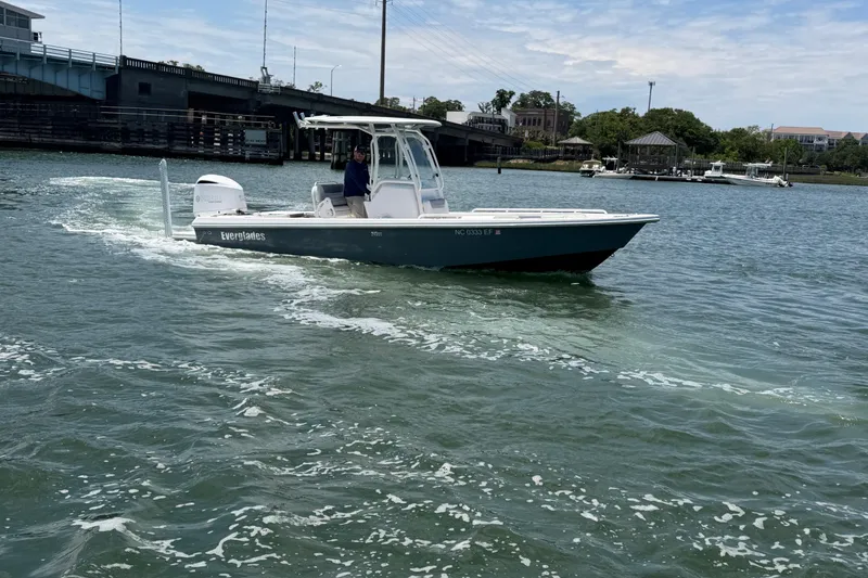 Slide: The Image of 2017 Everglades 243 Center Console boat cruising on a sunny day near a bridge. - 12