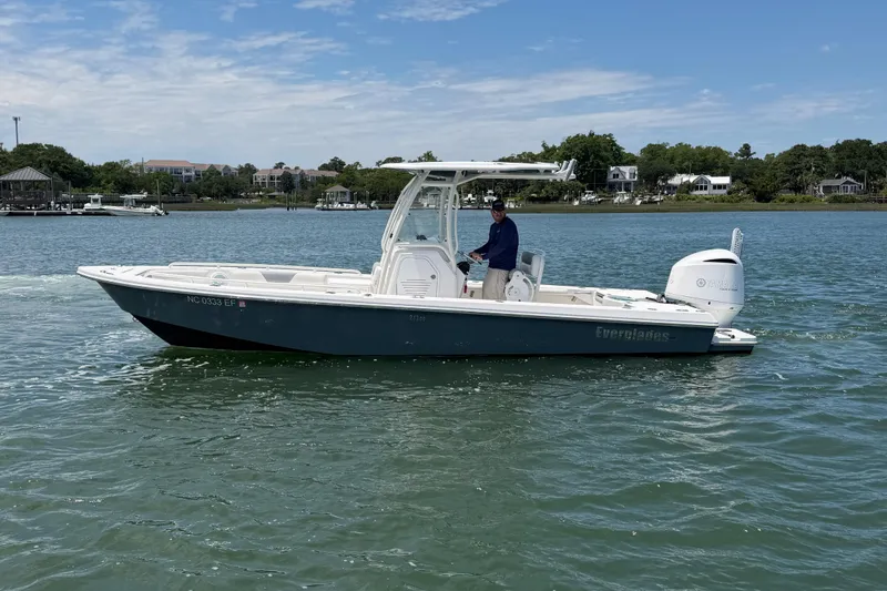 Slide: The Image of 2017 Everglades 243 Center Console boat cruising on a calm lake. - 13