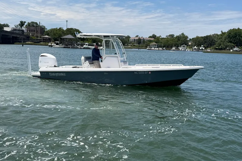Slide: The Image of 2017 Everglades 243 Center Console boat cruising on a calm lake. - 2