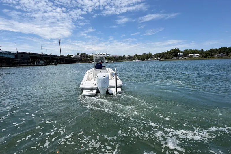Slide: The Image of 2017 Everglades 243 Center Console boat cruising on a sunny day near a bridge. - 21