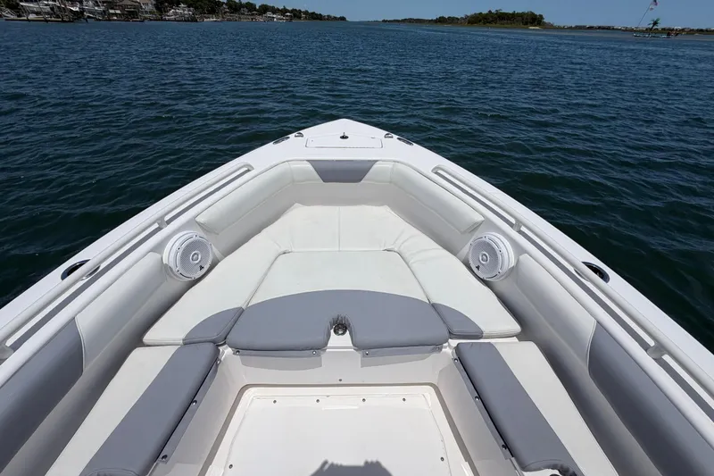 Slide: The Image of 2017 Everglades 243 Center Console boat interior with cushioned seating on calm water. - 29