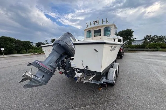 Slide: The Image of 2003 Parker 2120 Sport Cabin boat on trailer, parked outdoors under cloudy sky. - 11