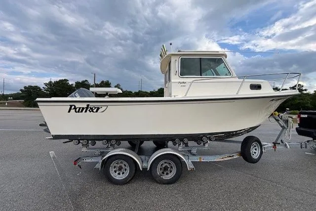 Slide: The Image of 2003 Parker 2120 Sport Cabin boat on trailer under cloudy sky. - 13