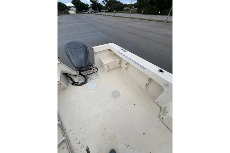 Slide: The Image of 2003 Parker 2120 Sport Cabin boat interior with motor, parked on a road. - 16