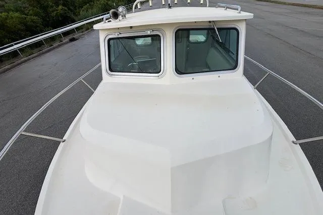 Slide: The Image of 2003 Parker 2120 Sport Cabin boat on a paved surface, showcasing its cabin and deck. - 19
