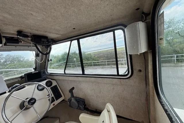 Slide: The Image of Interior view of a 2003 Parker 2120 Sport Cabin boat, featuring steering wheel and windows. - 21