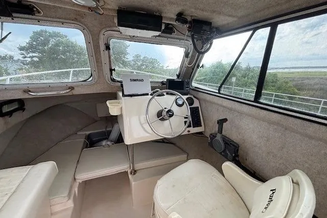 Slide: The Image of Interior of a 2003 Parker 2120 Sport Cabin boat with steering wheel and navigation equipment. - 22