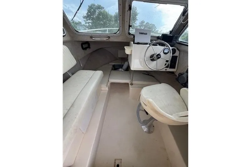 Slide: The Image of Interior of a 2003 Parker 2120 Sport Cabin boat with steering wheel and seating. - 23