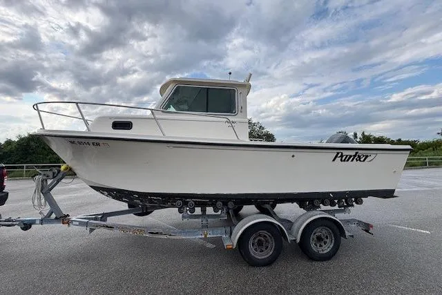 Slide: The Image of 2003 Parker 2120 Sport Cabin boat on trailer under cloudy sky. - 3