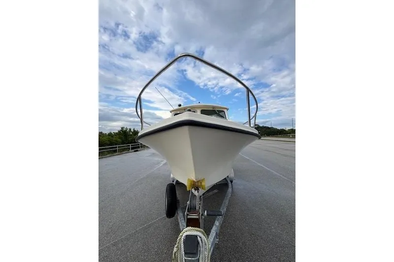 Slide: The Image of 2003 Parker 2120 Sport Cabin boat on trailer under cloudy sky. - 4