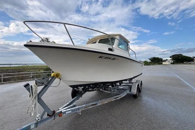 Slide: The Image of 2003 Parker 2120 Sport Cabin boat on trailer under a cloudy sky. - 5