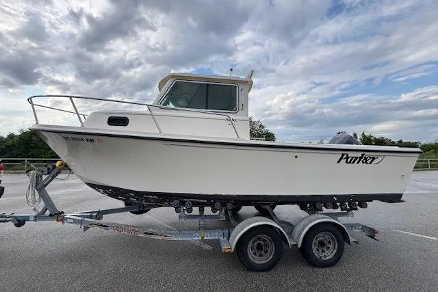 Slide: The Image of 2003 Parker 2120 Sport Cabin boat on trailer under cloudy sky. - 6