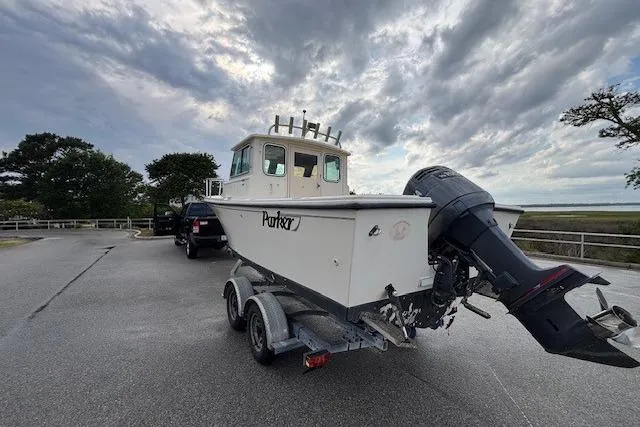 Slide: The Image of 2003 Parker 2120 Sport Cabin boat on trailer, parked under cloudy sky. - 7