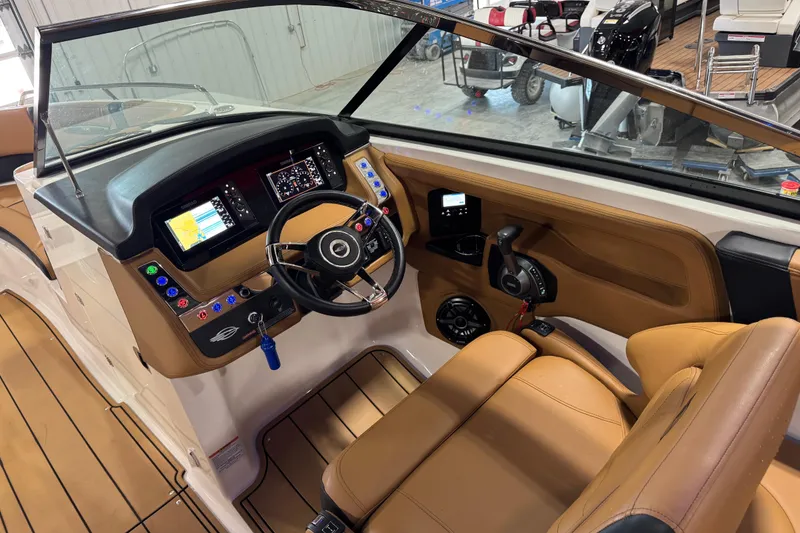 Slide: The Image of 2023 Chaparral 307 SSX boat cockpit with modern controls and tan leather seating. - 13