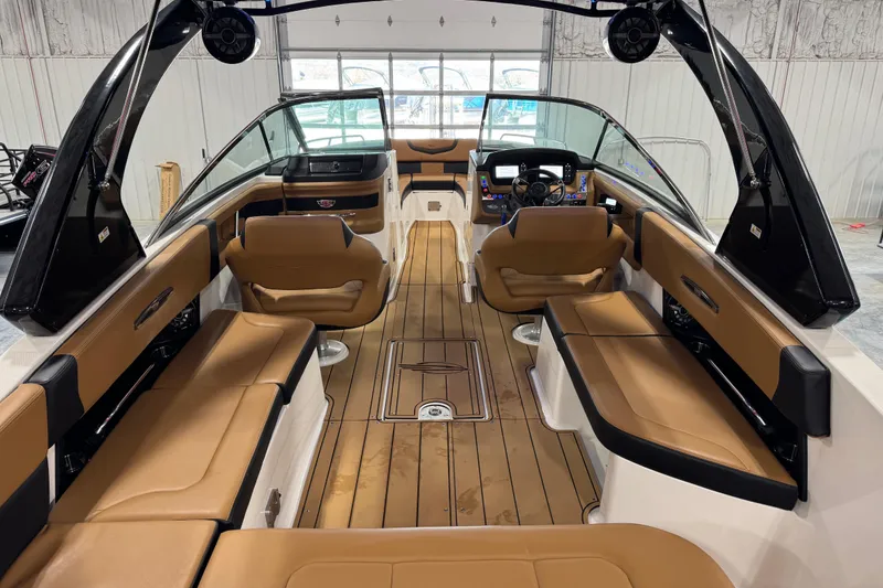 Slide: The Image of 2023 Chaparral 307 SSX boat interior with tan seating and modern dashboard. - 14