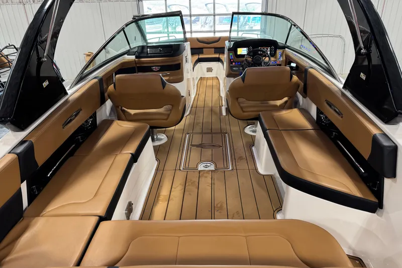 Slide: The Image of 2023 Chaparral 307 SSX boat interior with tan seating and sleek dashboard design. - 6